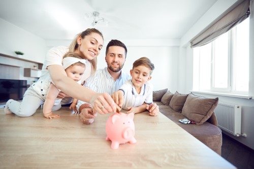 Familie wirft zusammen Geld ins Sparschwein